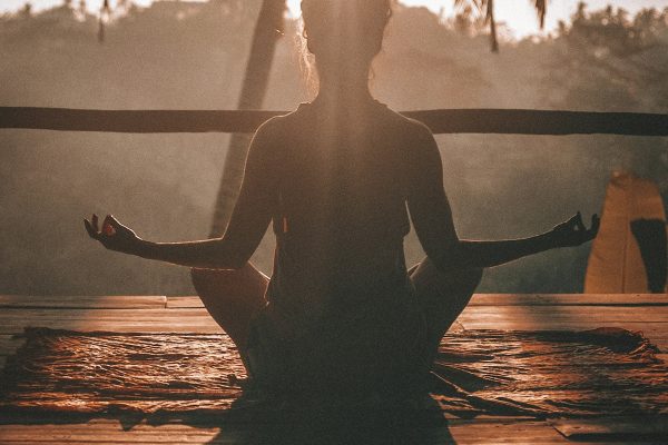 Peaceful morning meditation and yoga stretch routine in sunlit modern bedroom