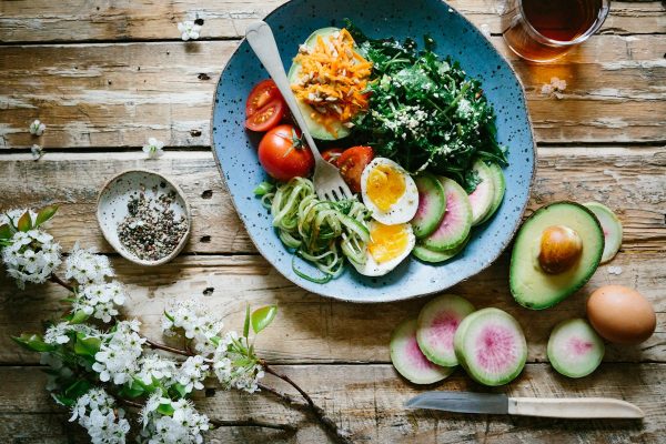 Balanced low-glycemic meal spread with avocados, healthy fats, fiber-rich vegetables, and proteins